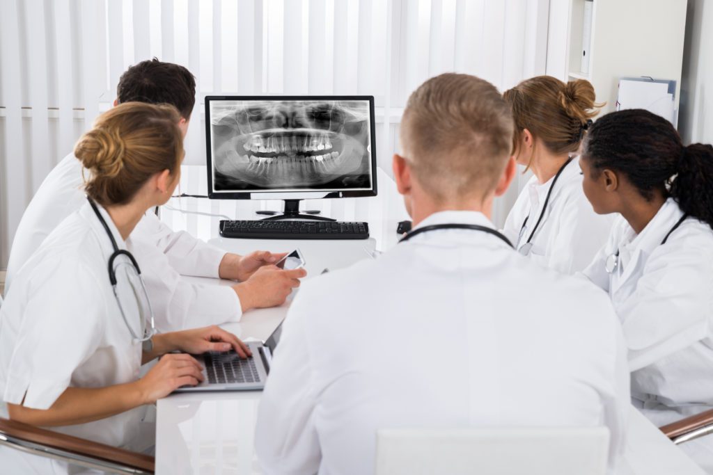Doctors Looking At Teeth X-ray On Computer